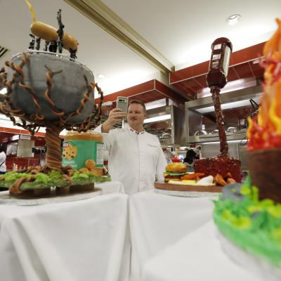 Several gravity cakes on display on a table covered with a white tablecloth.