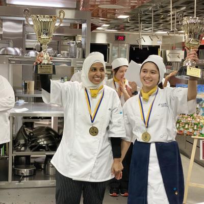 The winners of this year’s Humber Pastry Cup hold trophies in the air in celebration.