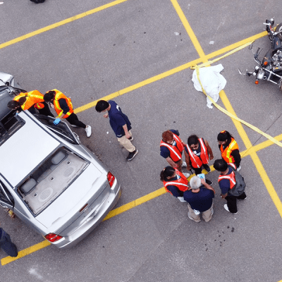 Students rescue mock patients from a vehicle as part of a simulated mass casualty event.