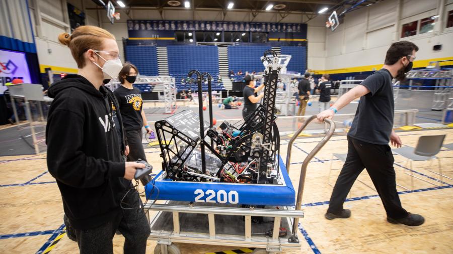 High school student pull their homemade robot across the gym at Humber College's North Campus