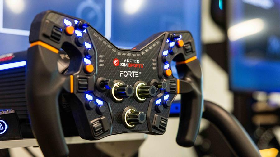 A closeup shot of a steering wheel with various buttons on knobs on it from a racing simulator.