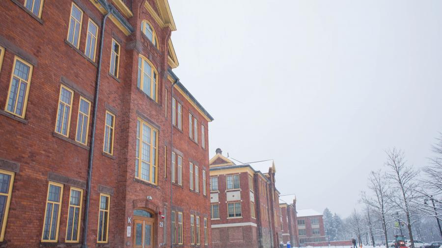 A brick building on Lakeshore campus seen from below, against a grey sky with snow on the ground