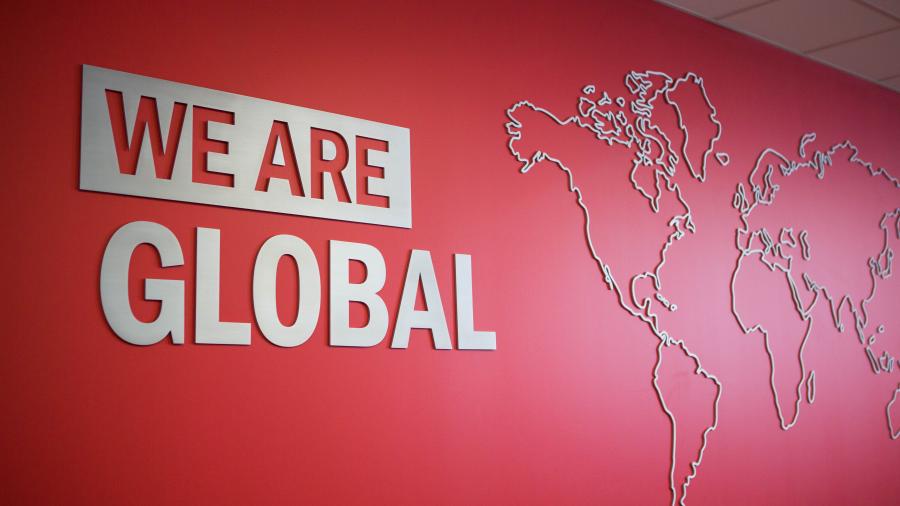 A red wall at Humber's International Centre with the words WE ARE GLOBAL printed beside a map outline