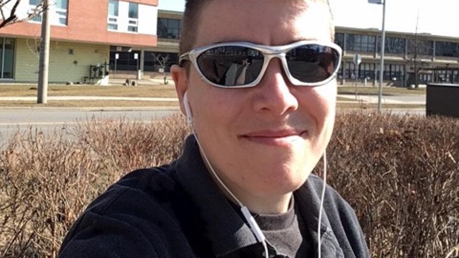 D Merkley takes a selfie across the street from a residence building at Humber's Lakeshore campus, wearing sunglasses