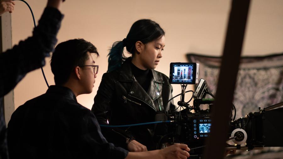 Two students work on a video camera on the studio set at Humber College
