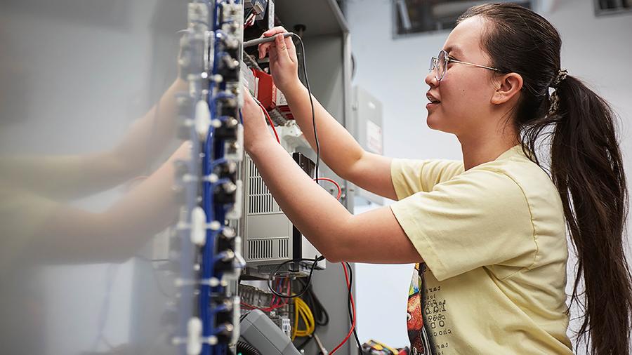 A person is using a tool to work on an electrical device.