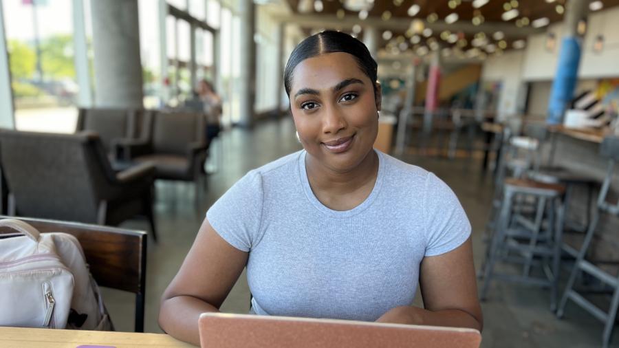 A person sits in front of a laptop computer.