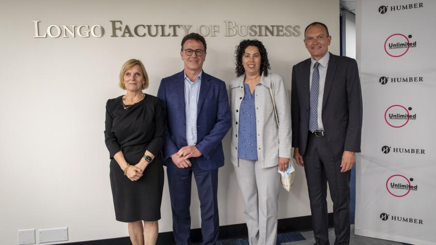 Four people – Alvina Cassiani, Anthony Longo, Rosanne Longo and Chris Whitaker – stand beneath a sign that reads Longo Faculty o