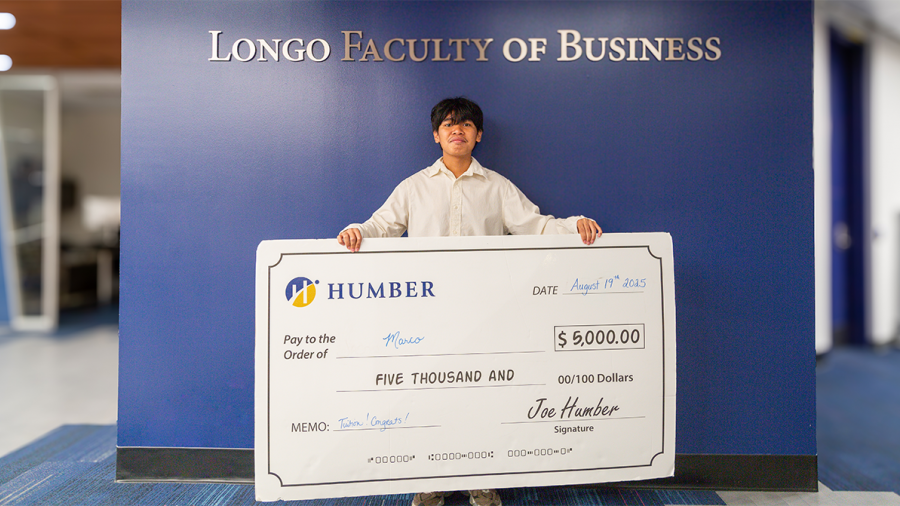 A person holds an oversized cheque in the amount of $5,000.