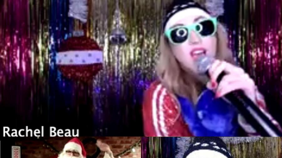 A screenshot of host Rachel Beau wearing flashy clothes and sunglasses in a split screen with Santa on Zoom
