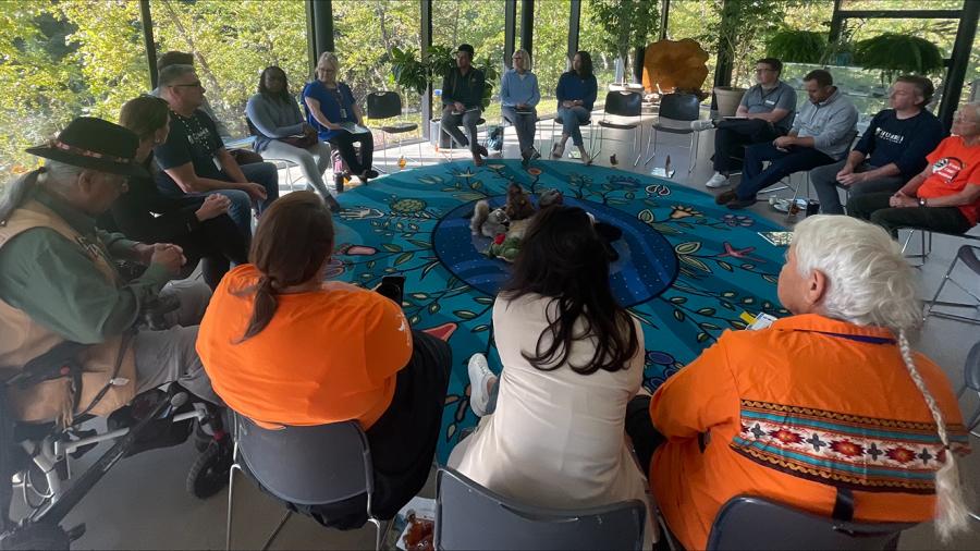 People sit in a circle while having a discussion.