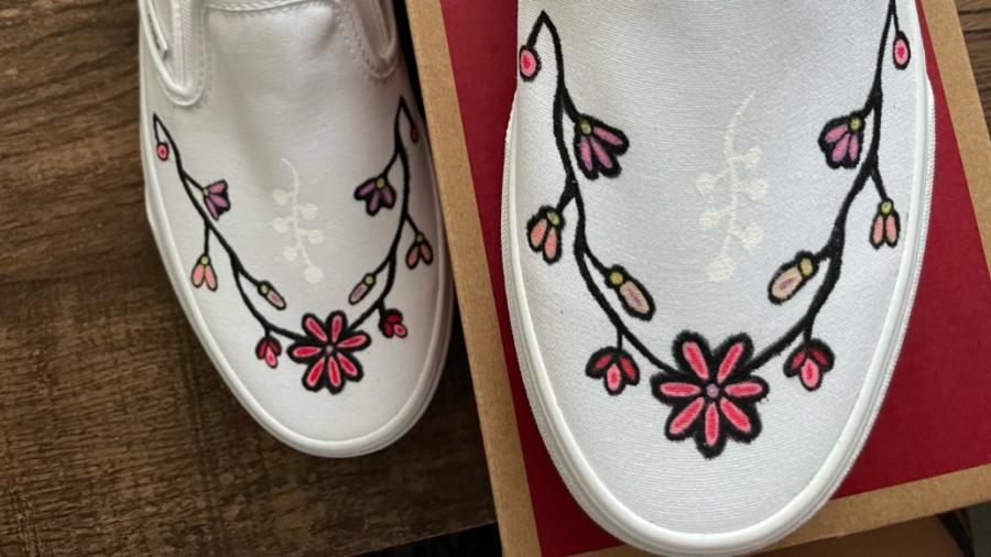 A pair of white shoes decorated with floral patterns.