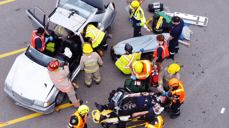 An overhead photo of students rescuing mock patients from a vehicle as part of a simulated mass casualty event.