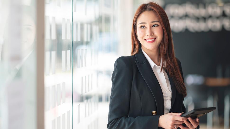 A smiling person is holding a device in their hands.