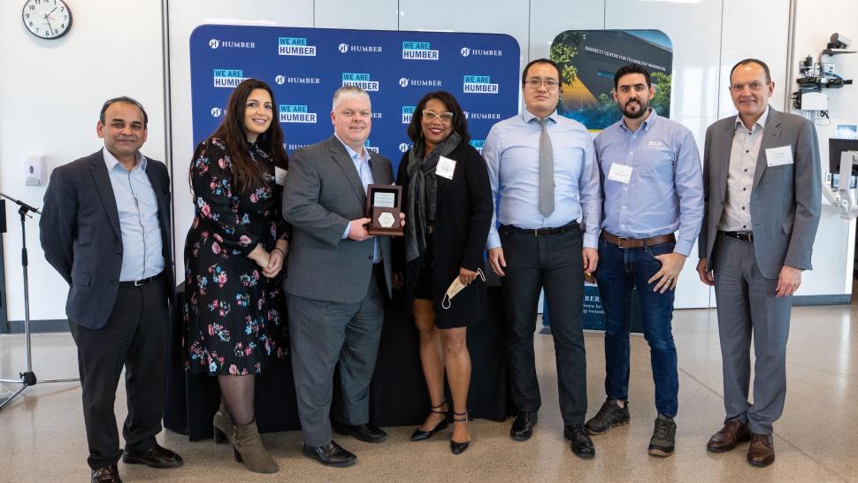 Representatives from Humber College and SICK, Ltd. hold a plaque to mark the partnership between the organizations