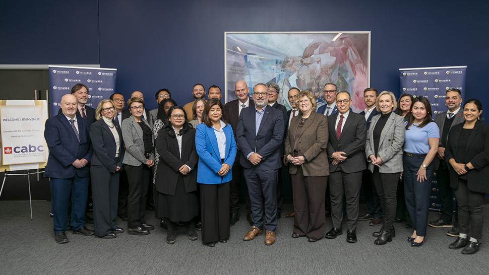 A group of people stand together in a boardroom.