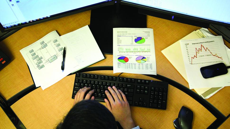 A student works at a computer with two monitors