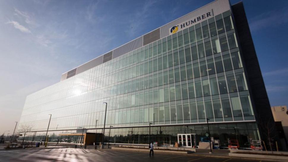 The Humber College Learning Resource Commons, which has a metal and glass facade. The sun is shining dramatically on it