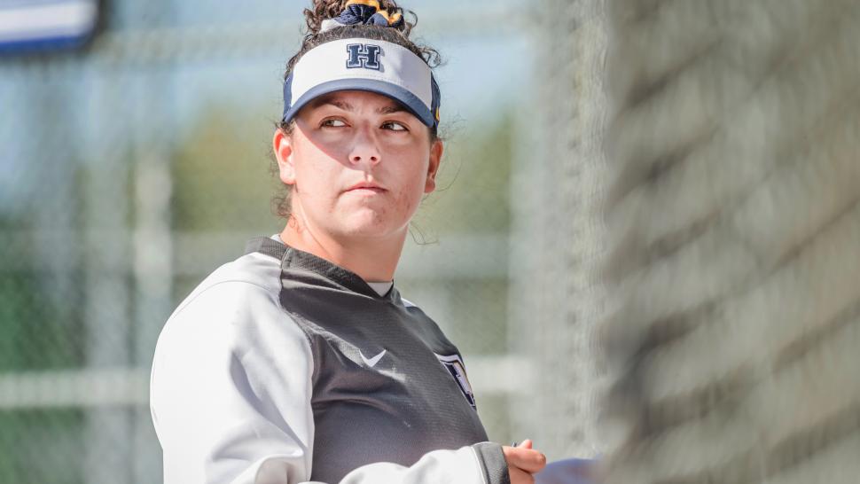 Jaime Vieira glances sideways on the baseball diamond in the bright sun, coaching Humber Hawks softball