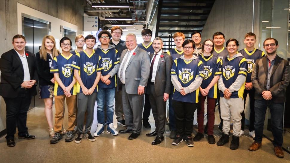 A group photo of the Humber Esports team in their varsity shirts with Doug Ford and Ross Romano
