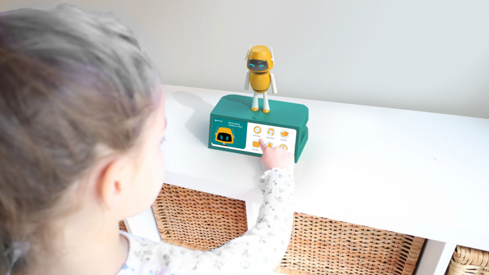 A child interacts with a small yellow and white Home Interactive and Virtual Exercise robot.