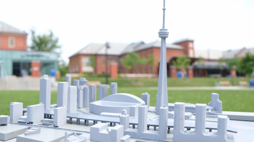 The interns' Tiny Town Model, grey skyscrapers and a tiny CN Tower is shown with the Lakeshore campus in the background