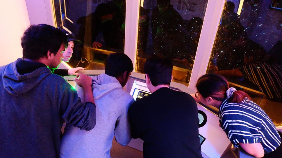 The Return to the Nebula Dawn is Humber Polytechnic’s spaceship-themed educational escape room. Several people are trying to solve a puzzle in an escape room.