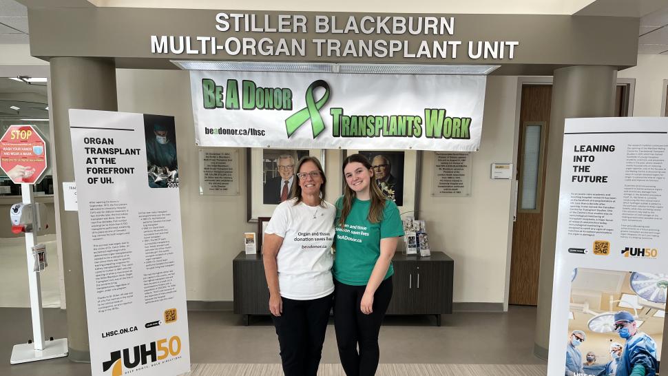 Two people stand beneath a sign that reads Stiller Blackburn Multi-Organ Transplant Unit.