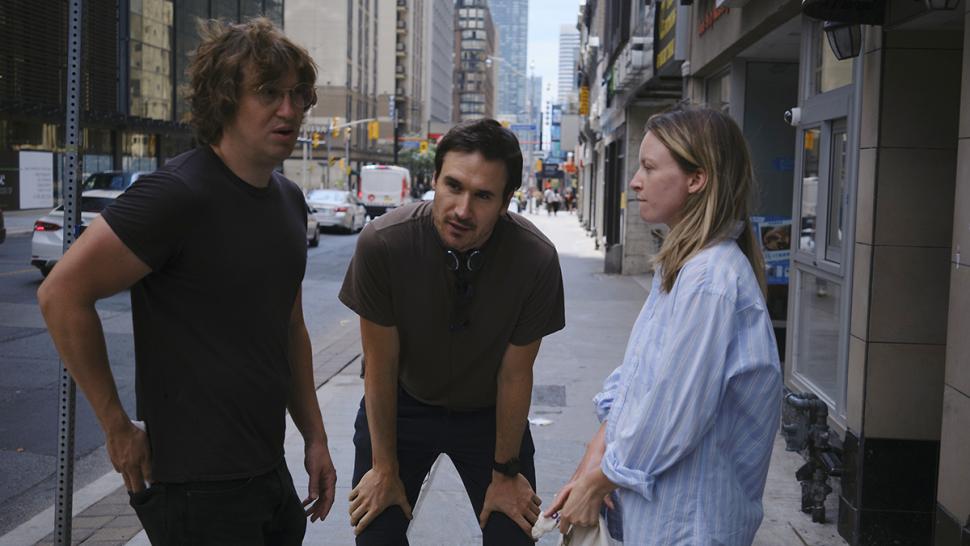 Humber Polytechnic professor Kazik Radwanski’s film Matt and Mara was included in Canada’s Top Ten for 2024. A person stands with their hands resting on their knees between two other people on a city street.