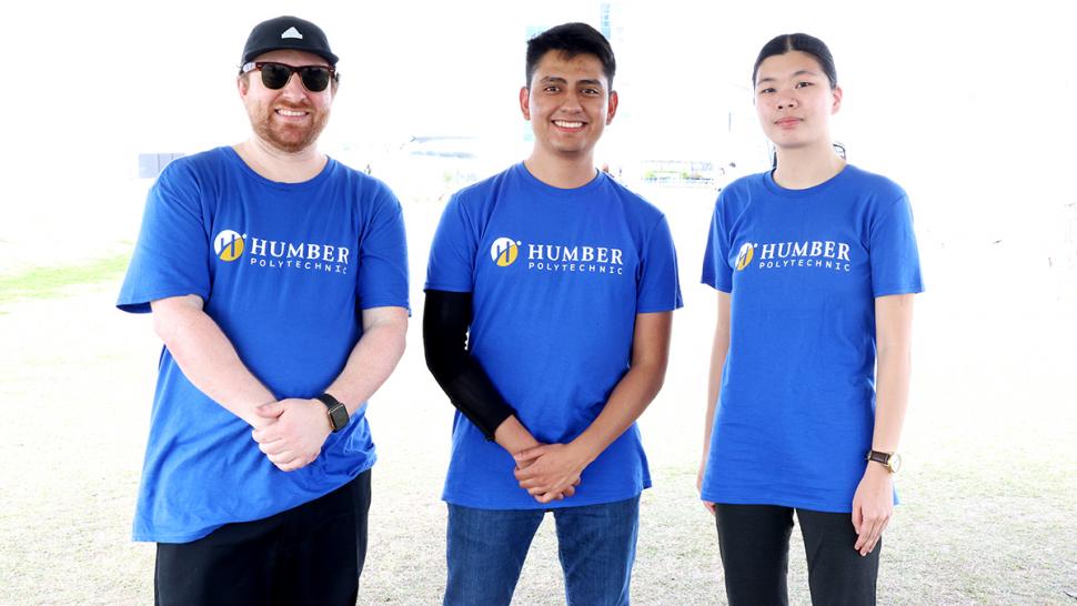Humber Polytechnic students participated for the first time ever at the RoboBoat 2025 competition. Three people wearing Humber Polytechnic tshirts stand together.