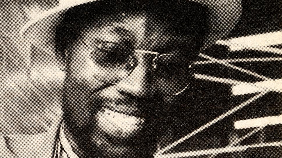 A smiling person shows off a number of medals hanging from around their neck.