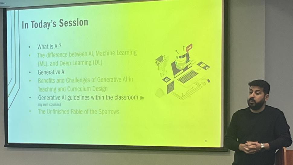The Faculty of Liberal Arts & Sciences invited Professor Ibrahim Tamim, who teaches Artificial Intelligence with Machine Learning at Humber College, to provide a presentation on the subject. A person stands beside a screen while talking. The screen has information about artificial intelligence on it.