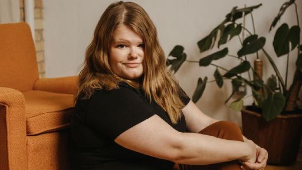 Humber College alumna Michelle McLeod plays Mejal in the Academy Award-nominated film Women Talking. Michelle McLeod sits with her arms resting over her leg.