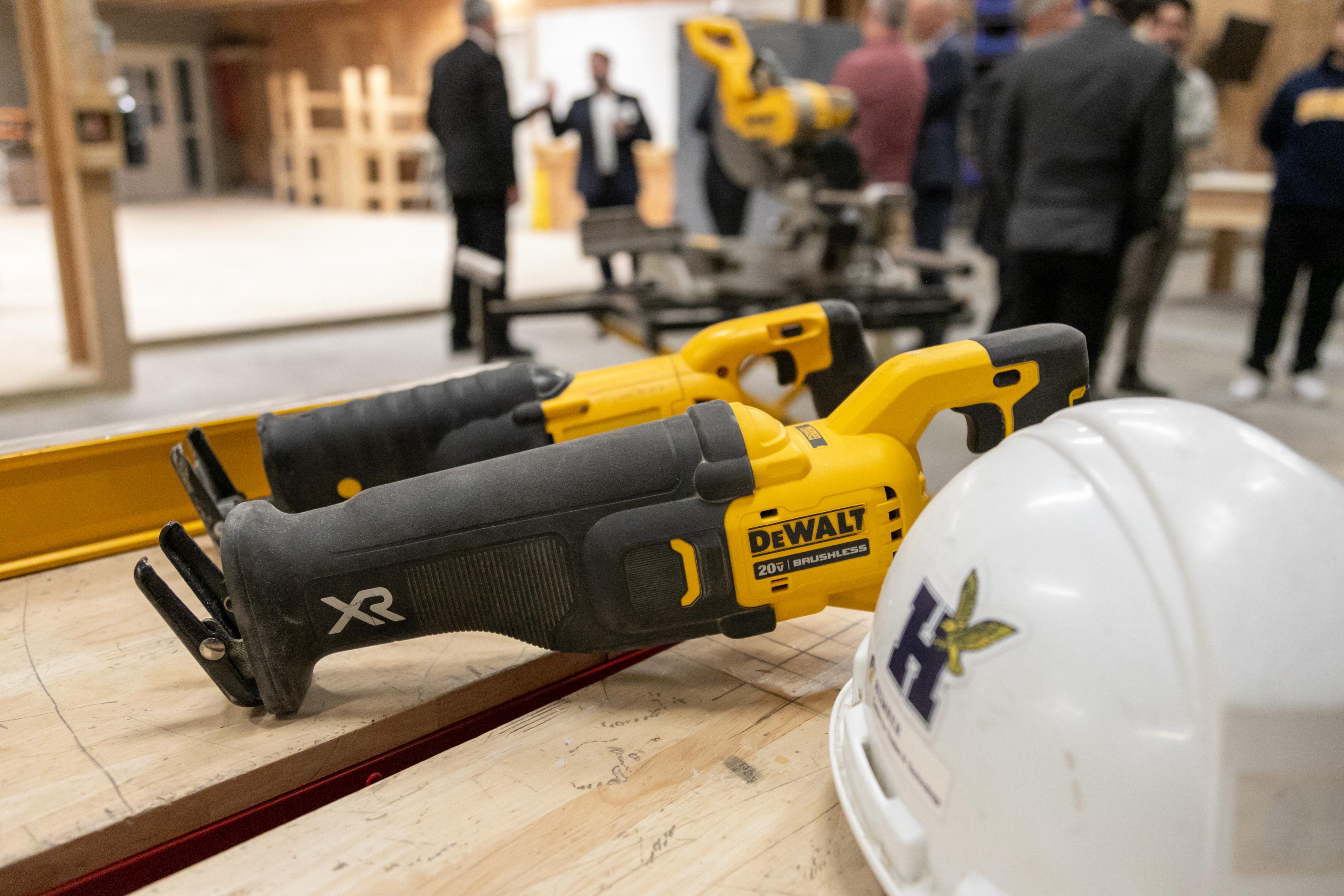DEWALT power tools sit on a table next to a helmet with the Humber College logo.