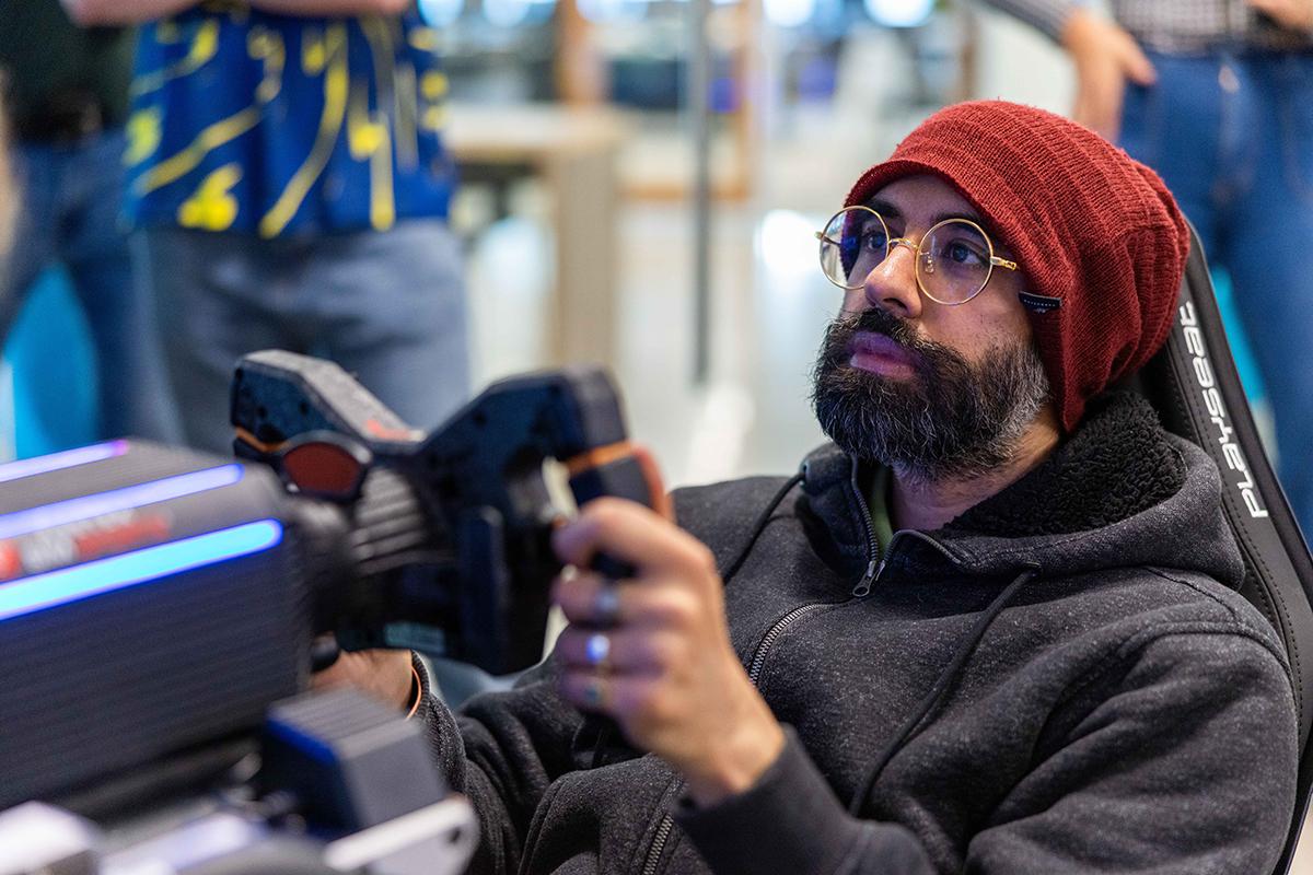 A person drives a racing simulator while sitting in it.