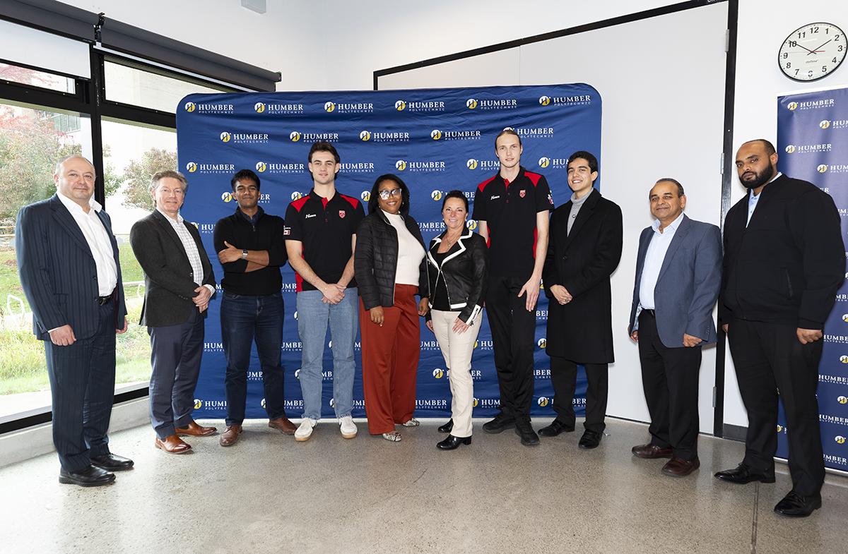 A group of people stand together in front of a Humber Polytechnic banner.