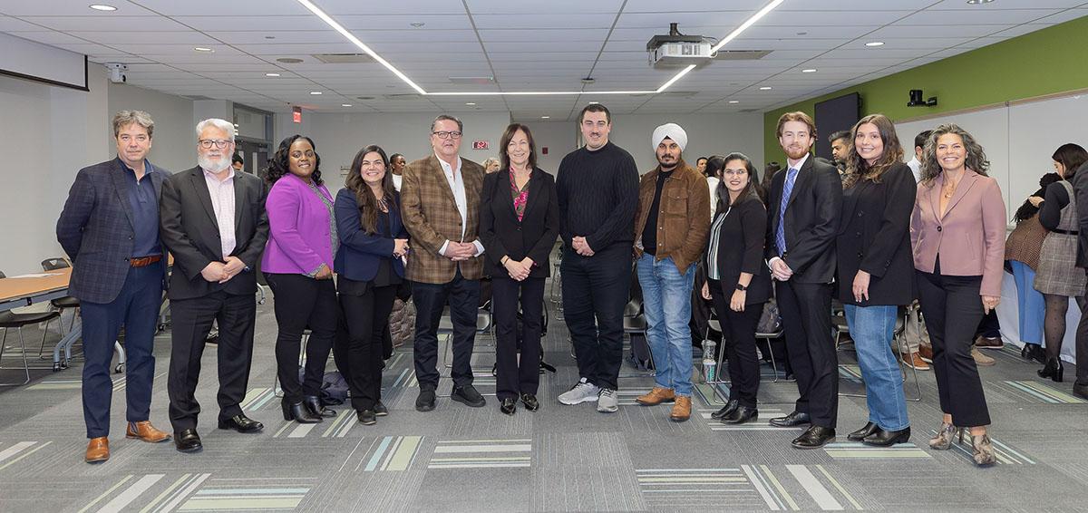 A group of people stand in a row as they pose for a photo.