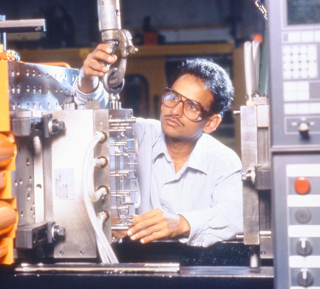 A person wearing safety glasses is interacting with a machine.