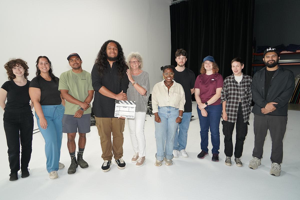 A group of people stand together on a film set.
