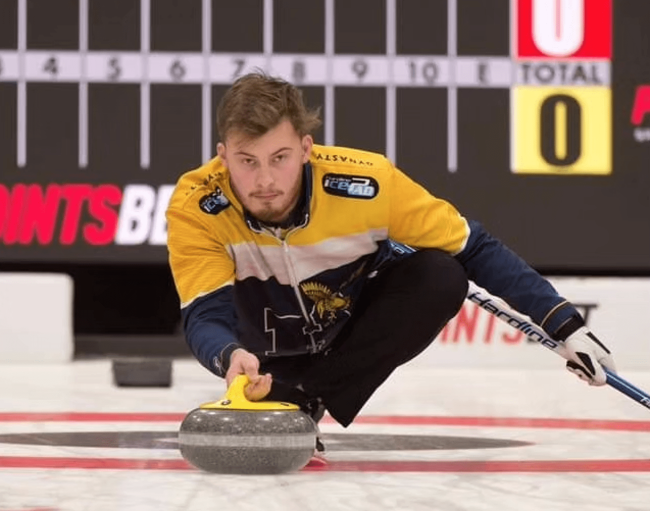 A curler prepares to send a rock down the rink.