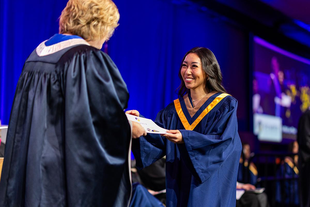 More than 3,100 graduates crossed the stage to receive their credential as part of Humber Polytechnic’s Fall 2025 Convocation ceremonies. A smiling person wearing graduation robes accepts a credential.