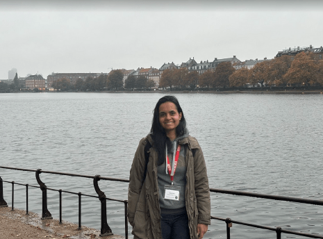 A person stands in front of a body of water.