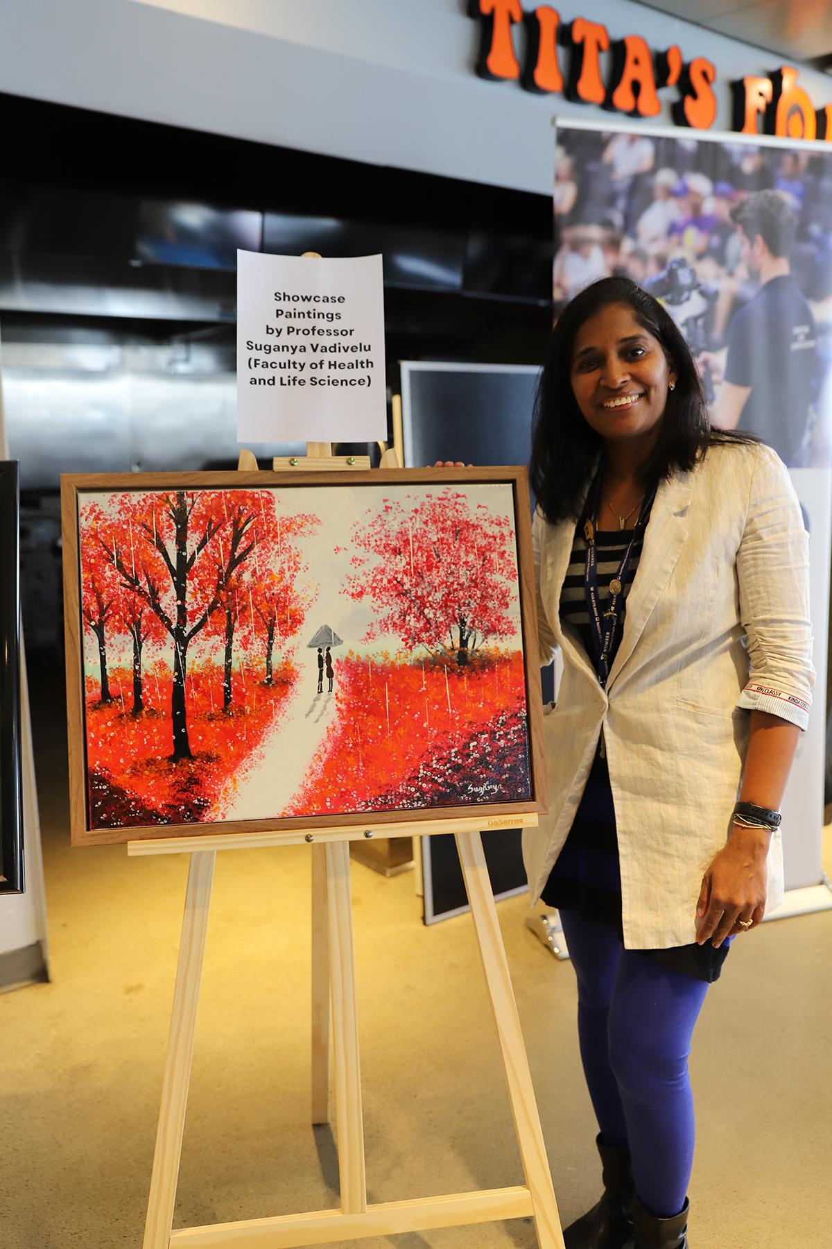 The Humber community raised more than $6,000 as part of the second annual Humber’s Got Talent event. A person stands with a painting.