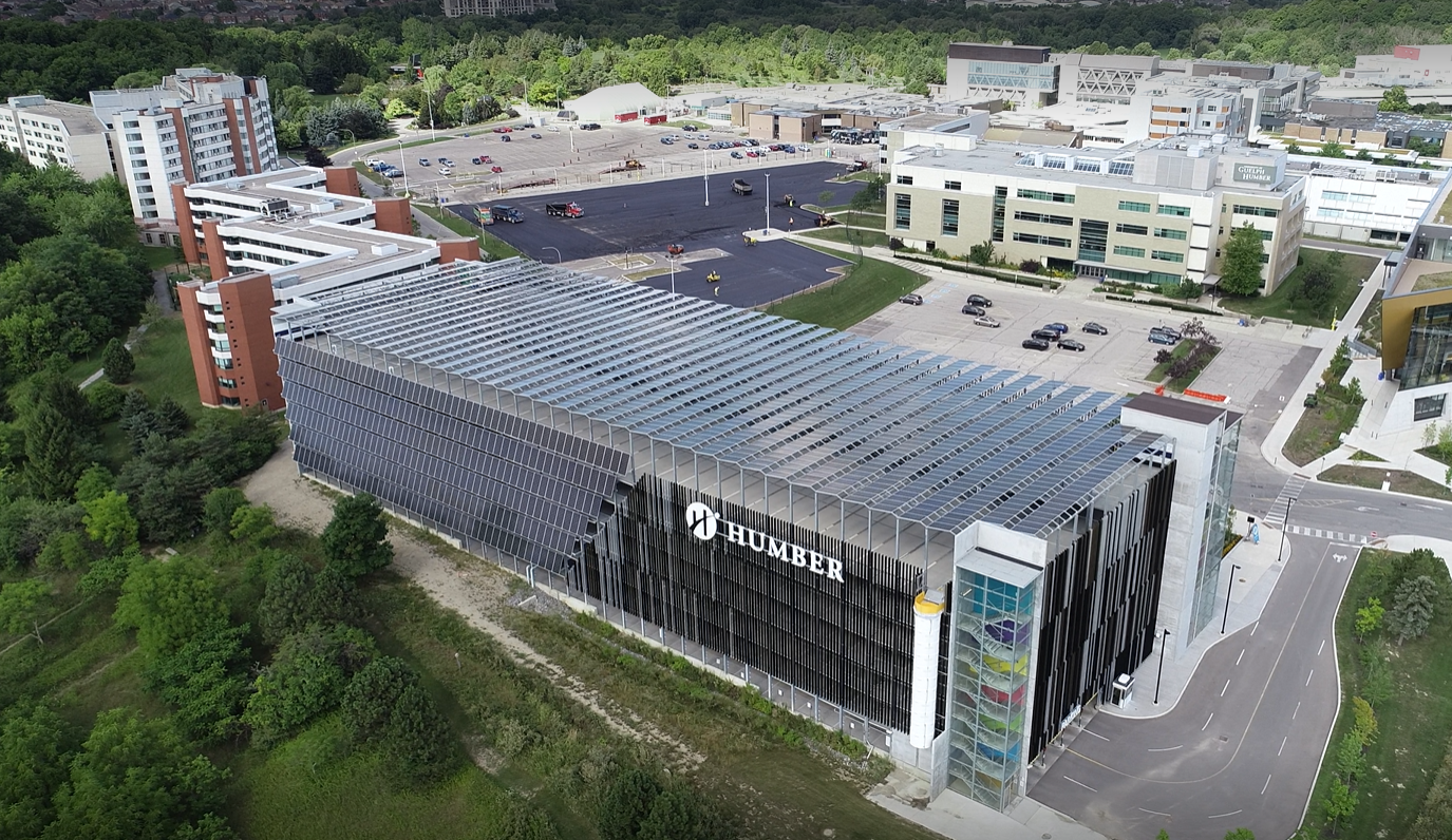 A multi-level parking structure with the Humber logo on it. The roof has solar panels installed on it.