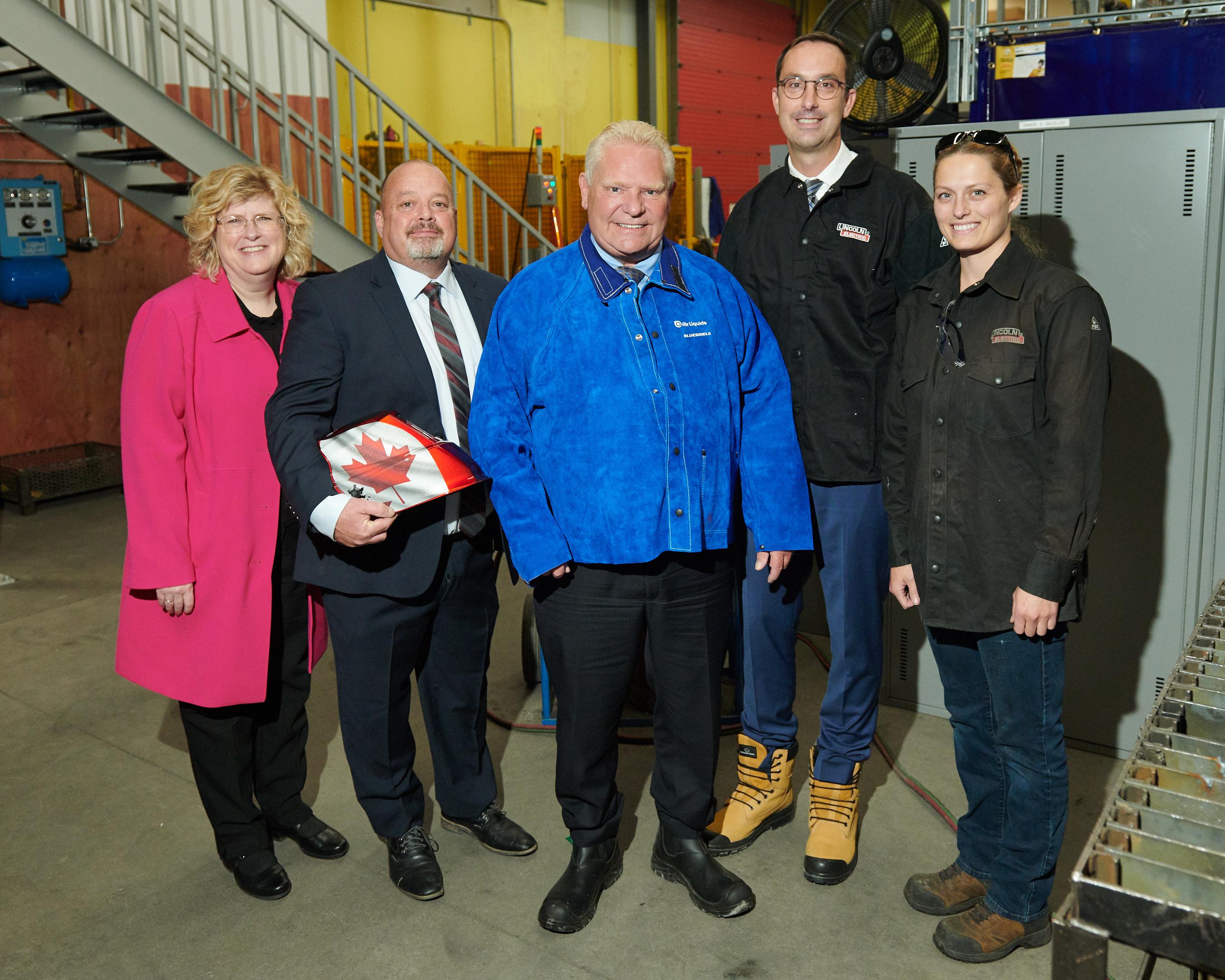 Five people stand together in a learning lab at Humber Polytechnic’s Centre for Skilled Trades and Technology. 