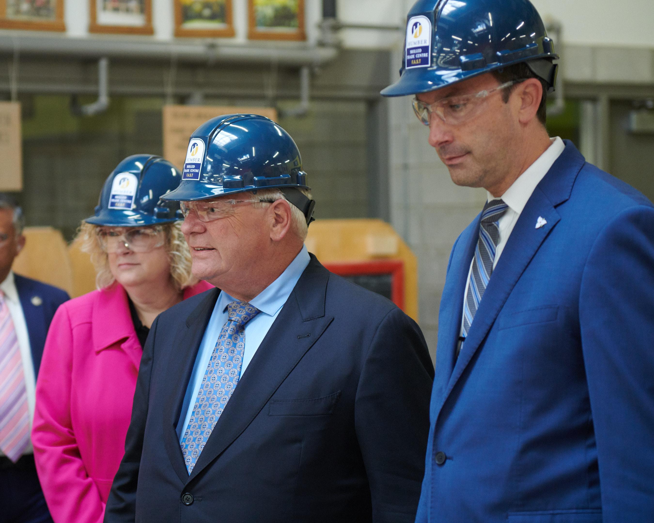 Three people are wearing hardhats.