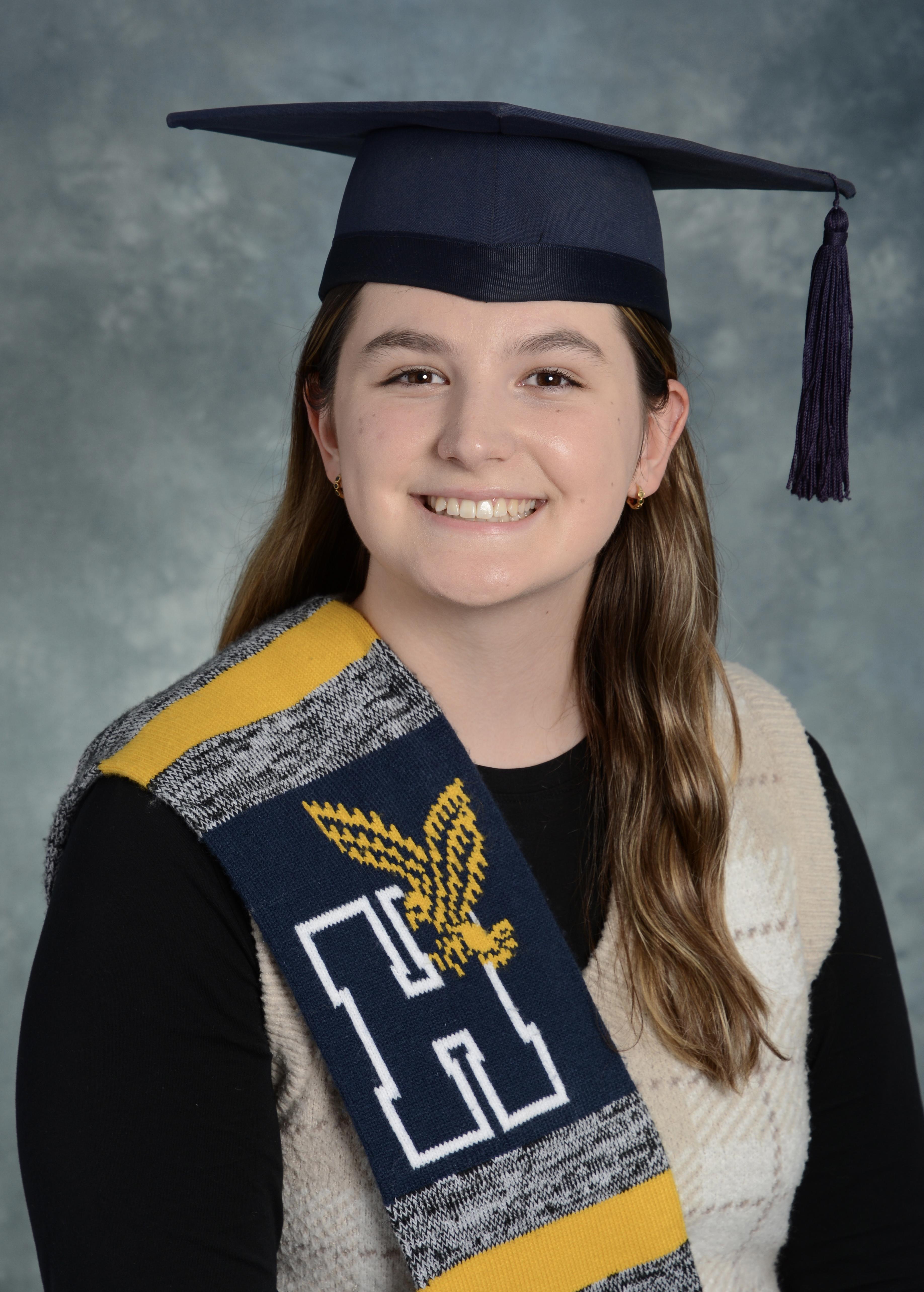A head-and-shoulders photo of a person wearing a graduation cap and a Humber scarf.