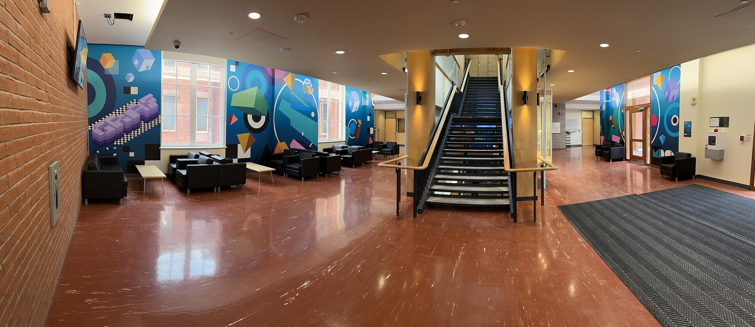 A panoramic shot of a series of brightly coloured murals. There is a staircase in the middle of the room.
