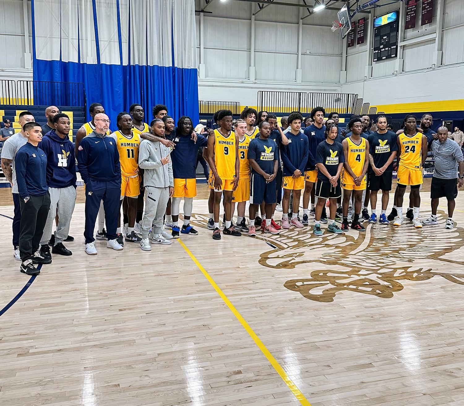 Athletes wearing Humber Hawks uniforms stand together in a gym.