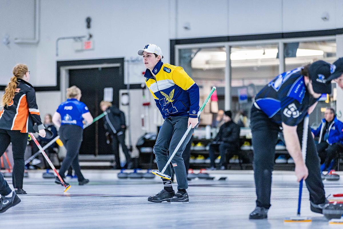 A person wearing Humber Hawks apparel is curling.